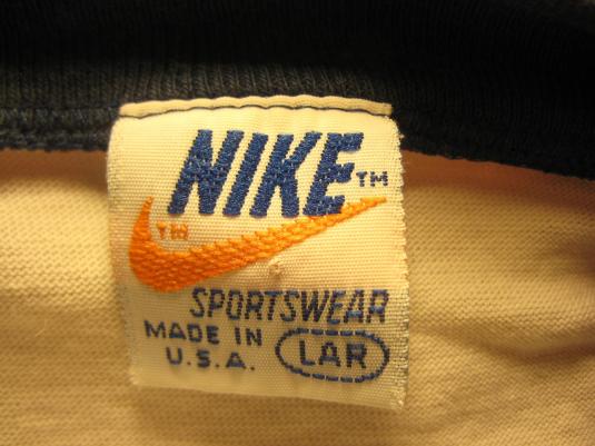 Vintage Nike neck tag with the Nike wordmark in blue above an orange swoosh, reading SPORTSWEAR and MADE IN U.S.A. with size LAR