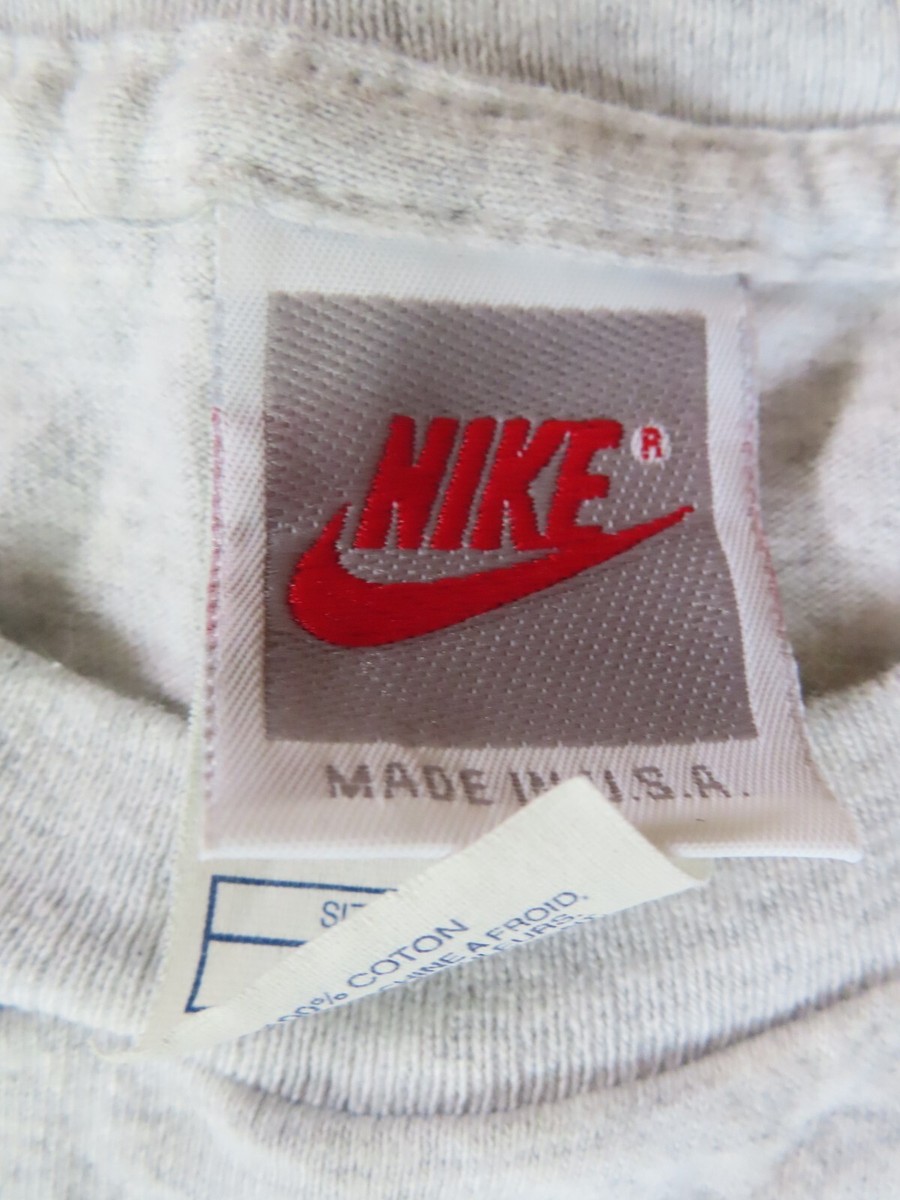 Vintage Nike grey neck tag, a grey rectangle inside a white rectangle with the Nike wordmark and swoosh in red, MADE IN U.S.A. below