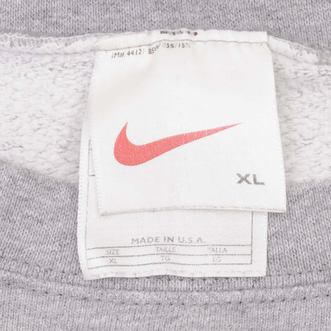 Vintage Nike white neck tag, thin white label with a red swoosh and no wordmark, size XL, MADE IN U.S.A. on the label beneath