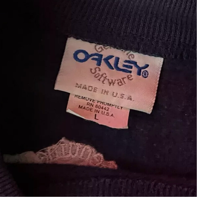Salmon-pink satin Oakley tag reading Genuine Oakley Software, Made in USA, RN 60442
